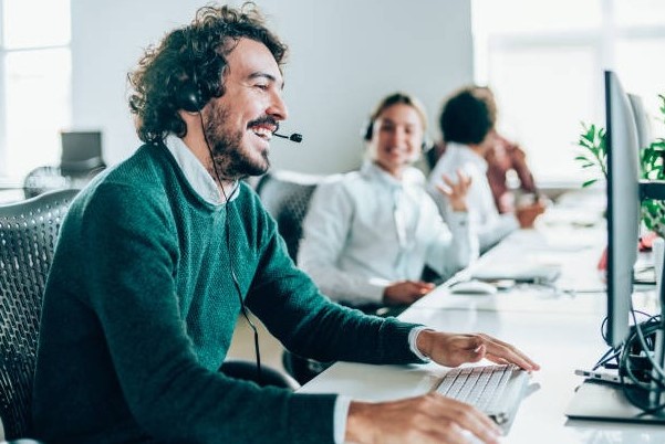 Smiling call center agent at computer